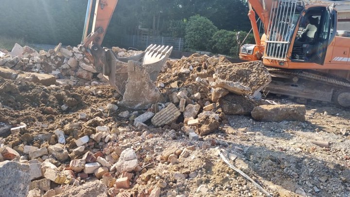 Bagger mit Sortiergreifer sortiert Bauschutt bei Abbrucharbeiten im Kreis Herford