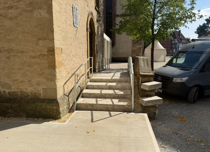 Fertige Natursteintreppe mit Rampe und Edelstahl-Handlauf an einer Kirche in Herford