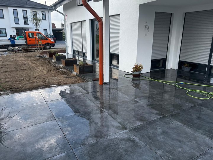 Neue Terrasse mit großformatigen Anthrazit-Platten an einem Neubau im Kreis Herford